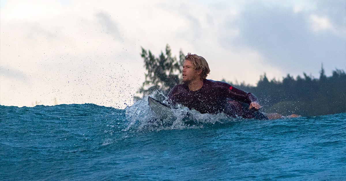 John John Florence paddles out on his surf board